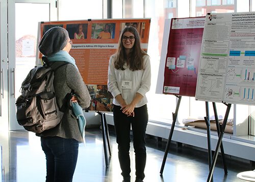 Students having a conversation in the Campus Center about their research. 